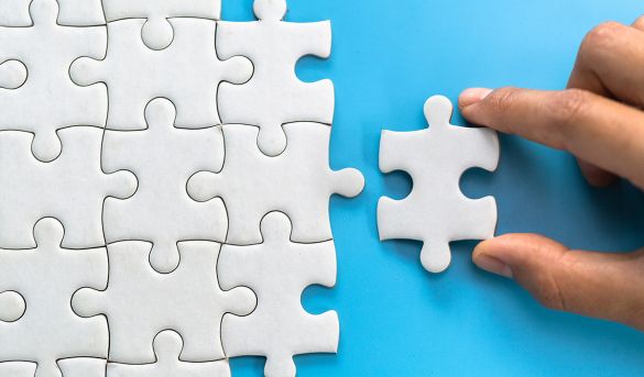 Hand einer Frau verbindet Puzzelteile