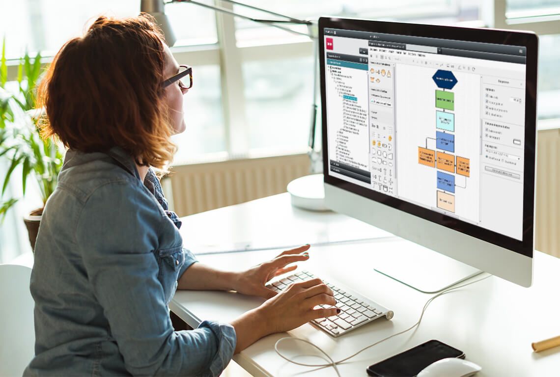 Eine Frau erstellt am Computer ein Prozessablaufdiagramm