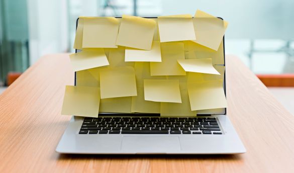 Laptop steht Schreibtisch und Bildschirm ist komplett mit gelben Klebezettel beklebt