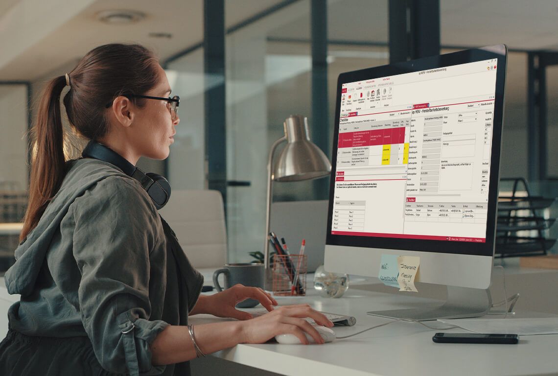 Eine Frau bearbeitet am Computer eine Herstellbarkeitsanalyse