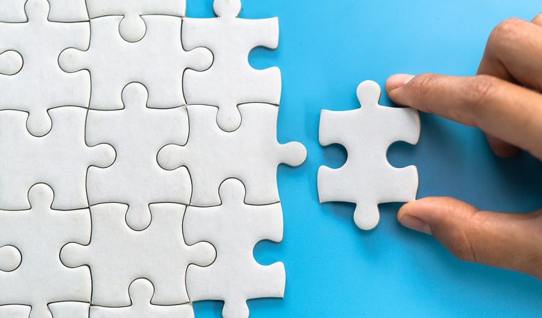Hand einer Frau verbindet Puzzelteile