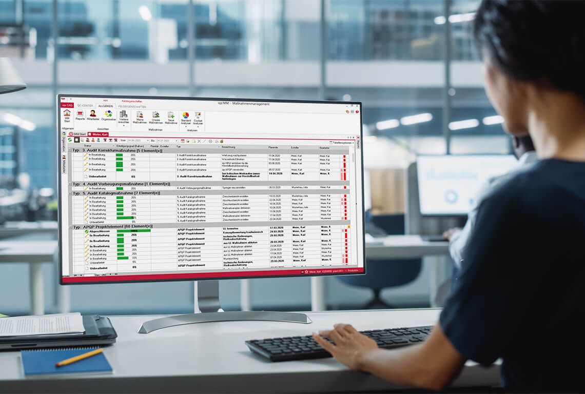 Eine Frau sitzt vorm Computer und bearbeitet ihre Maßnahmen